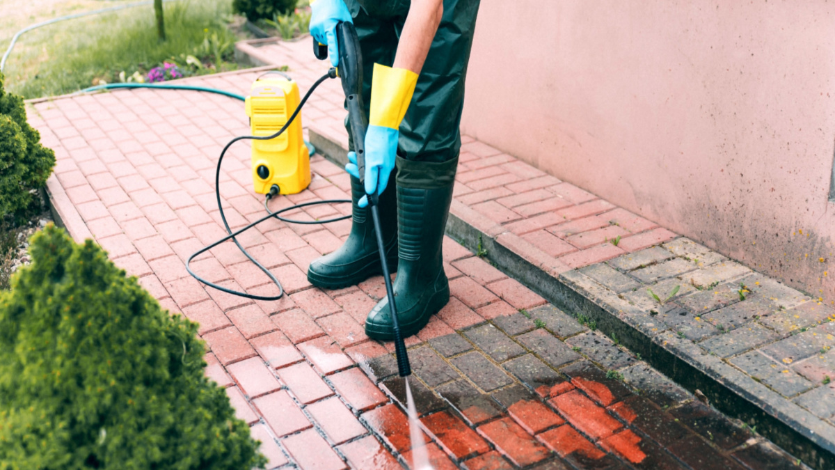 person pressure washing patio
