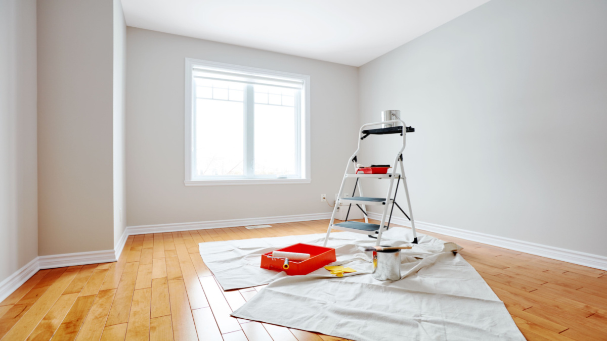 Empty room with hardwood floor and gray walls to be painted