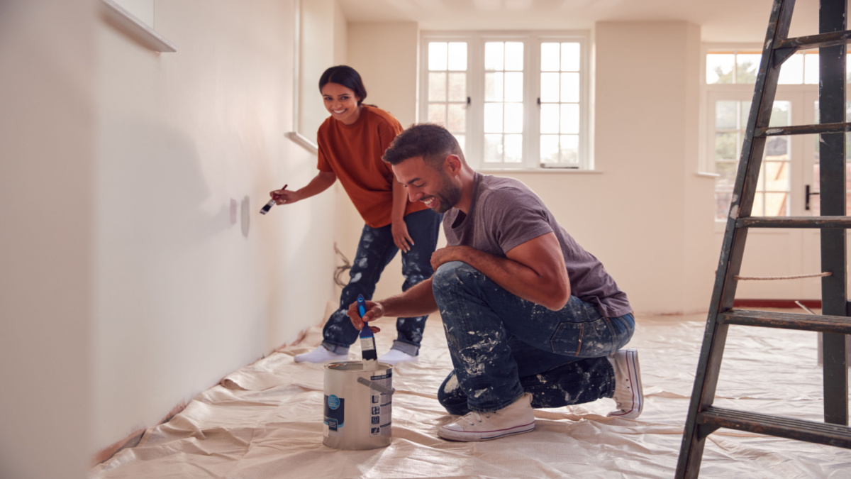 Couple painting an interior room in their house